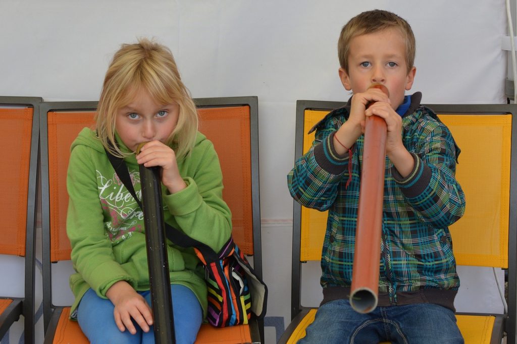 Kinder spielen Didgeridoo